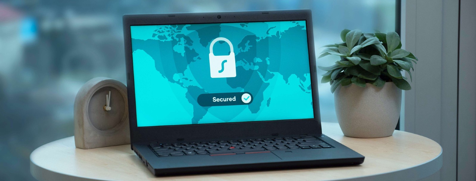 Image shows a laptop on a table with a security lock on a screen